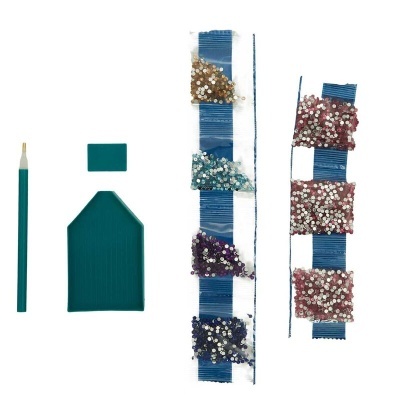 Materiais de artesanato com ferramenta, placas verdes e tiras azuis com pedaços brilhantes