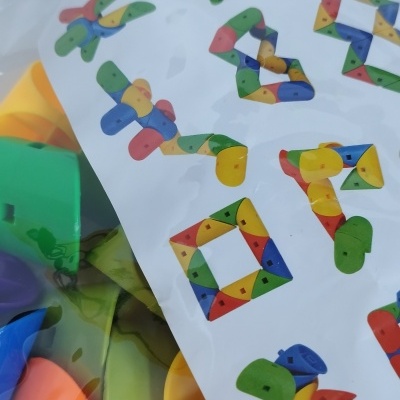 Blocos de construção de cores variadas em embalagem com instruções e título 'PUZZLE BLOCKS'.