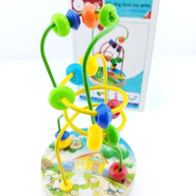 Brinquedo educativo de arames coloridos com contas sobre base de madeira redonda com desenho de animais e casa