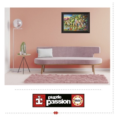 Puzzle de vila colorida em moldura preta na parede rosa acima de sofá lilás com almofada branca e mesa com plantas