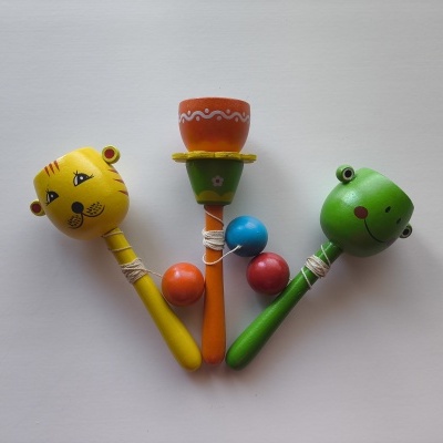Três maracas de madeira coloridas com formas de animais e objetos