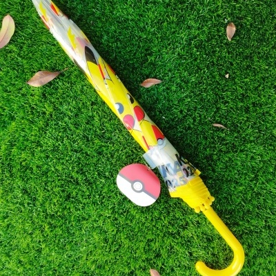 Guarda-chuva fechado amarelo com desenho de Pikachu sobre relva verde