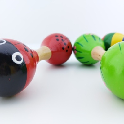 Conjunto de maracas de madeira coloridas com padrões e olhos desenhados