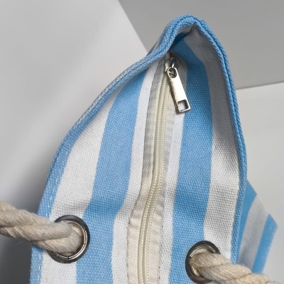 Bolsa às riscas azuis e brancas com fecho e alças de corda.