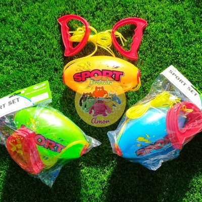 Três conjuntos de brinquedos desportivos de plástico colorido sobre relva artificial