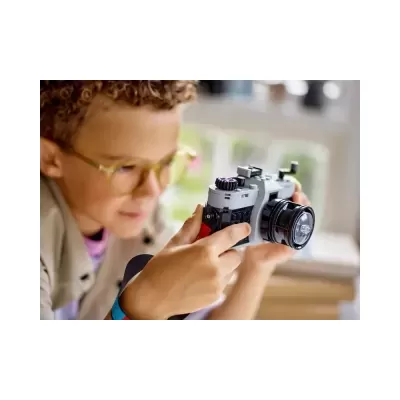 Criança com câmara fotográfica de brinquedo cinza e preto
