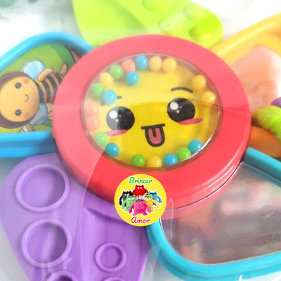 Brinquedo infantil colorido em forma de flor com rosto sorridente no centro