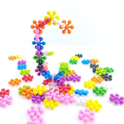 Peças plásticas em forma de flores coloridas sobre fundo branco