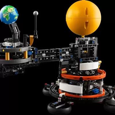 Modelo de sistema planetário em blocos de construção coloridos sobre fundo preto.