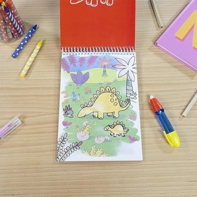 Caderno de colorir com desenho de dinossauros e lápis de cor ao redor