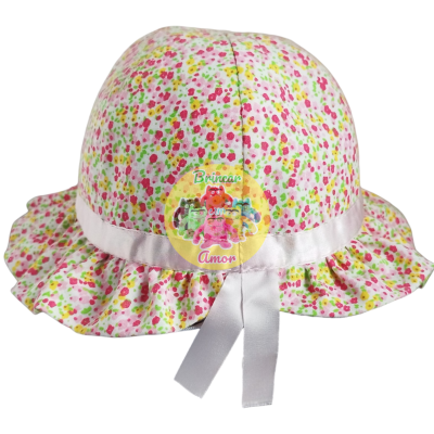 Chapéu infantil colorido com padrão de manchas e fita branca.