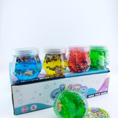 Conjunto de quatro potes de slime colorido com pedras dentro em embalagem branca azul
