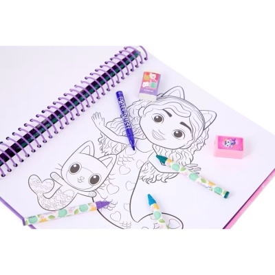 Caderno de desenho aberto com desenhos para colorir, lápis de cor, marcador azul e borrachas sobre superfície branca.