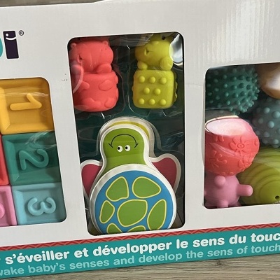 Embalagem de brinquedos coloridos LUDI com blocos numerados e brinquedos texturizados.