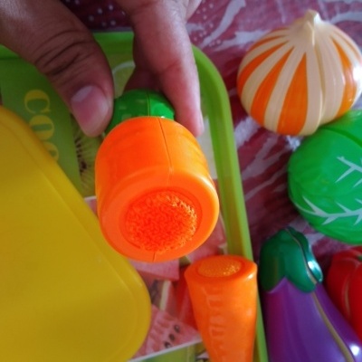 Jogos de legumes de plástico coloridos sobre uma bandeja verde