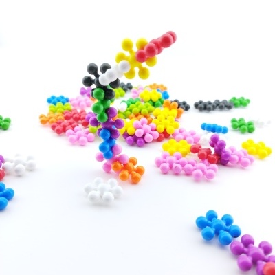 Peças coloridas em forma de flor de plástico num fundo branco