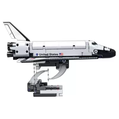 Modelo de brinquedo da nave espacial Space Shuttle branca com detalhes pretos e suporte.