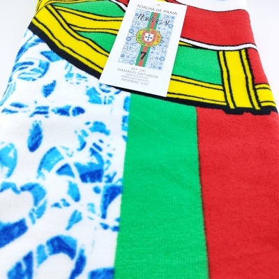 Toalha de praia colorida com a bandeira de Portugal e etiqueta visível