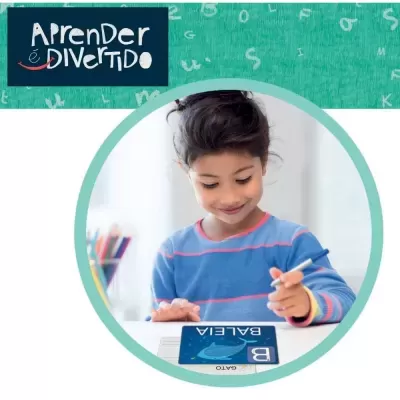 Criança a aprender com ficha de estudo da baleia e texto Aprender é DIVERTIDO.