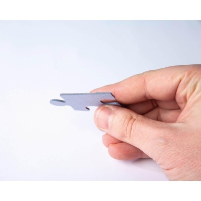 Mão a segurar peça de puzzle cinzenta