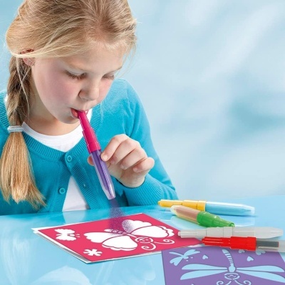 Criança a usar caneta sopradora para colorir desenhos com marcadores