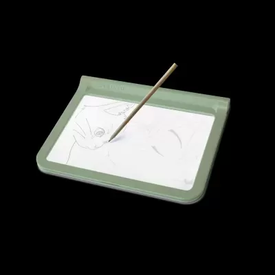 Mesa de luz verde clara com papel e lápis para desenho