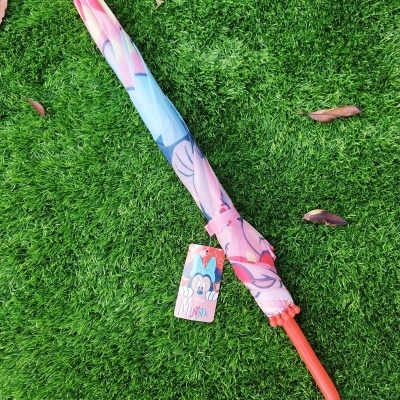 Guarda-chuva colorido com padrão gráfico e etiqueta Minnie da Disney sobre relva verde