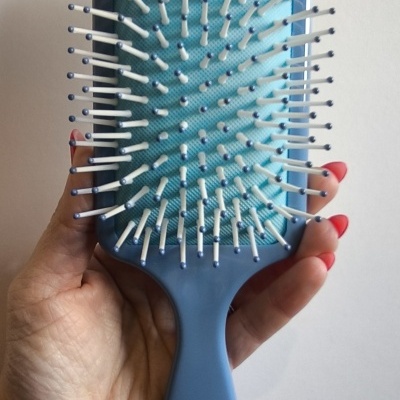 Escova de cabelo azul claro com cerdas brancas e bolinhas azuis