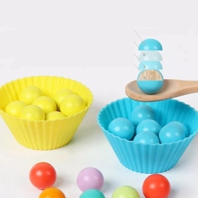 Bolas coloridas em formas de silicone amarelas e azuis com colher de madeira.