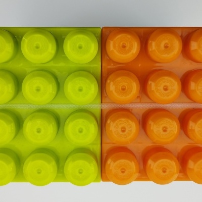 Blocos de construção de plástico verde neon e laranja organizados em duas fileiras