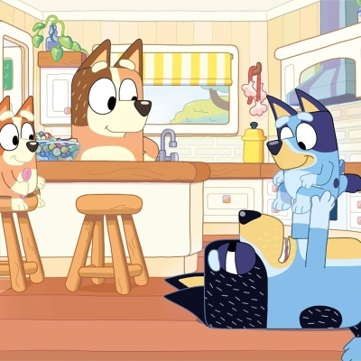 Cães animados em cozinha moderna com móveis de madeira clara e eletrodomésticos brancos