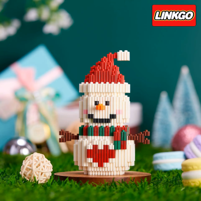 Boneco de neve de blocos de montar com chapéu de Pai Natal e coração vermelho sobre base de madeira