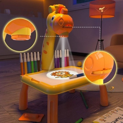 Secretária infantil em forma de girafa com luz projetada e canetas coloridas numa sala