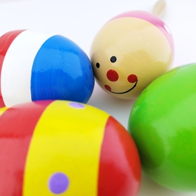 Maracas coloridas de madeira com diferentes padrões e uma com rosto sorridente.