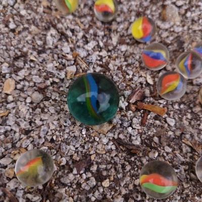 Bolas de vidro coloridas sobre cascalho cinzento