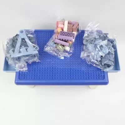 Base azul com várias peças de construção coloridas em sacos plásticos