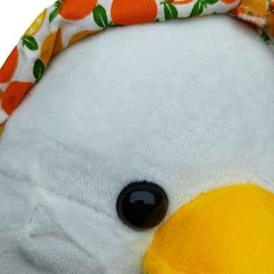 Pelúcia de pássaro branco com bico amarelo e bandana e lenço estampados com frutas