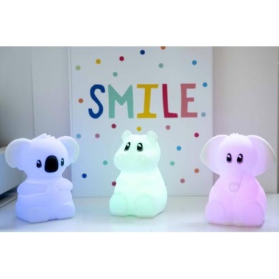 Três candeeiros infantis em forma de animais iluminados com a palavra SMILE ao fundo