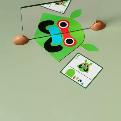 Espelho com imagem colorida de maçã verde e carta com imagem idêntica