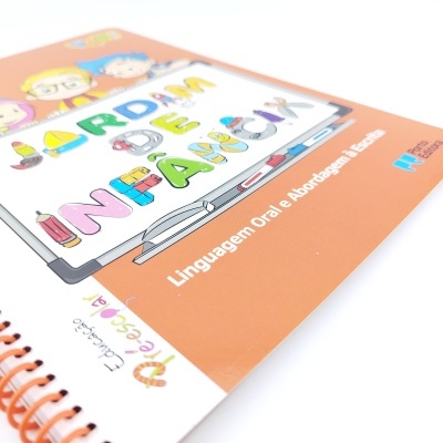 Caderno espiral laranja com ilustração colorida e texto educativo.