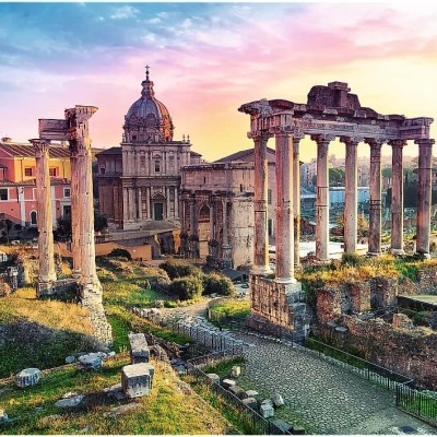 Ruínas antigas com colunas de pedra e edifícios históricos ao pôr do sol