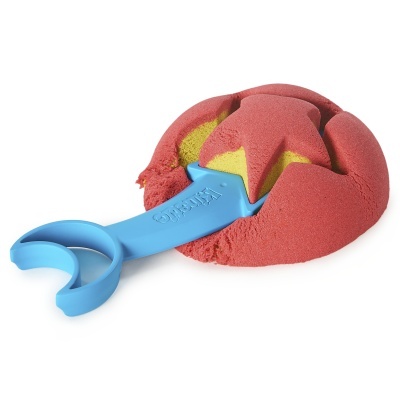 Areia cinética vermelha e amarela com espátula azul para cortar