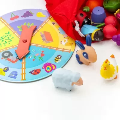 Jogo infantil colorido com tabuleiro e peças de animais de plástico com saco vermelho