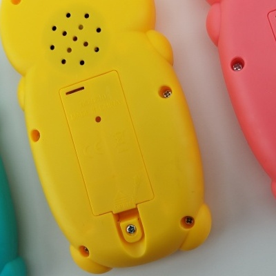 Três brinquedos eletrónicos coloridos azul, amarelo e vermelho sobre fundo branco