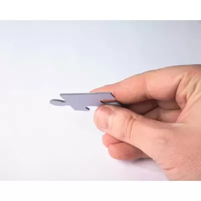 Peça de puzzle cinzenta a ser segurada por mão masculina