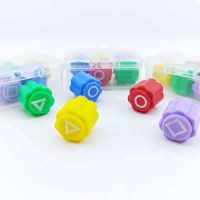 Marcadores de espuma coloridos com formas geométricas em caixas transparentes