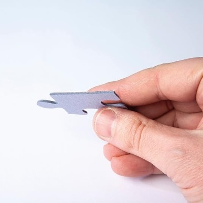 Mão a segurar peça de puzzle cinzenta mate