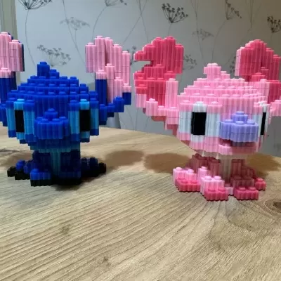 Duas figuras de blocos de construção pixel art azul e rosa sobre mesa de madeira