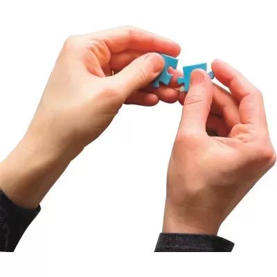 Duas mãos a unir peças azuis de puzzle.