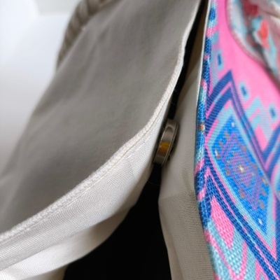 Mochila de tecido bege com interior colorido e padrão geométrico